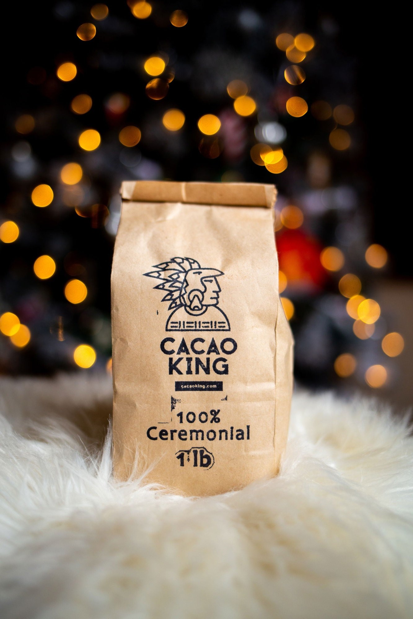 A bag of ceremonial cacao resting on sheepskin, warm lights glowing behind it